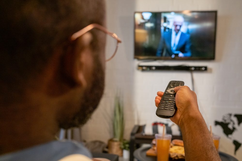 person holding remote control of tv